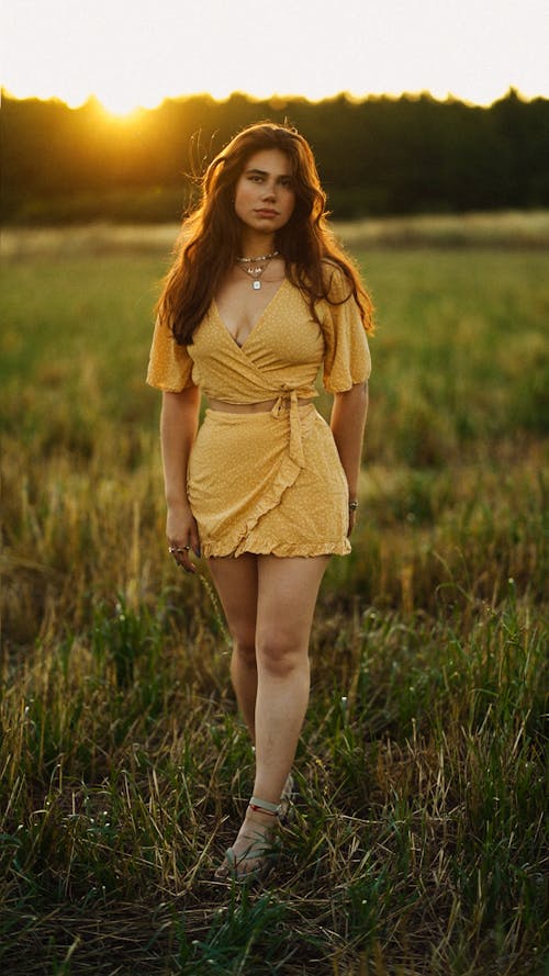 Young Woman in a Dress Posing on a Field