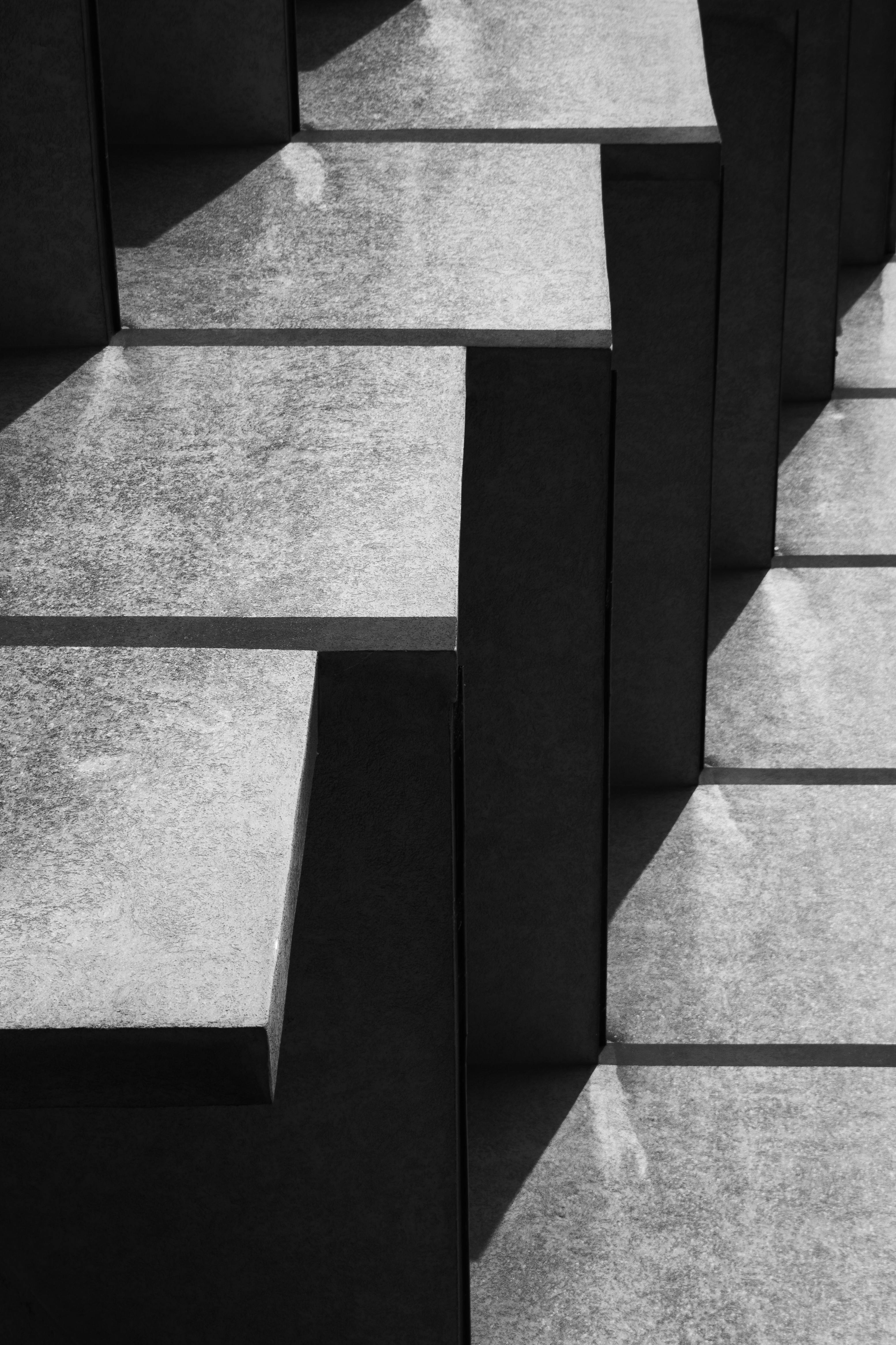 Geometric black and white photo of concrete steps casting sharp shadows.