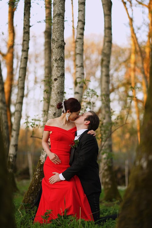 A Couple in Elegant Clothes Kissing in the Forest
