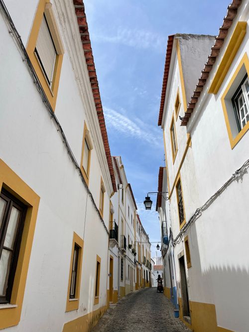 Free A picturesque view of a narrow, colorful alleyway with traditional architecture under a clear sky. Stock Photo