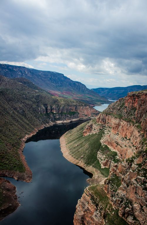 Free A breathtaking aerial view of a canyon with a winding river under overcast skies, offering a scenic masterpiece. Stock Photo