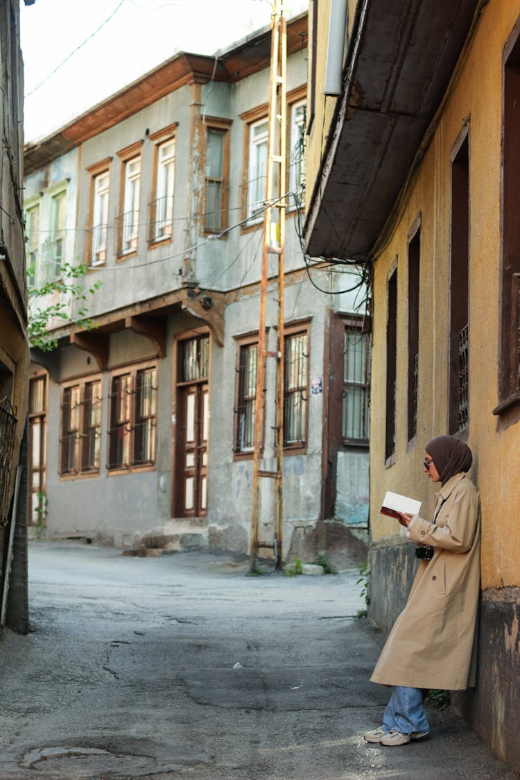 Woman Reading A Book On A Street 