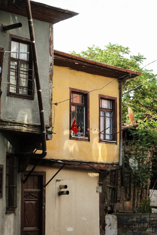 Free Historic Turkish townhouse with flag in window, capturing rustic architecture. Stock Photo