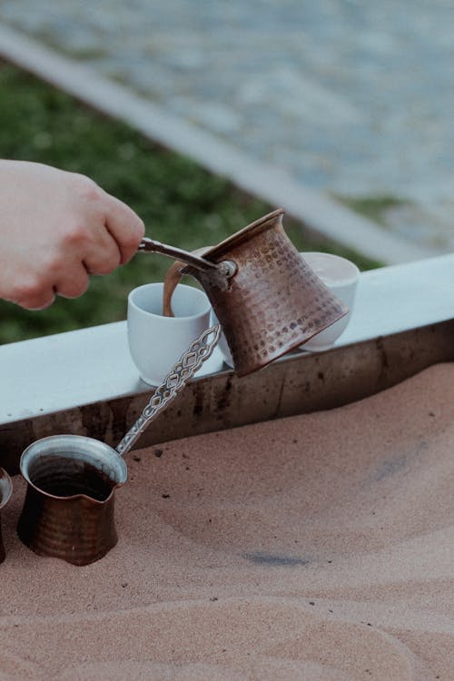 Person Pouring Coffee into the Cup 