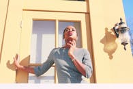 一位时尚女性身着连衣裙，在明媚的阳光下自信地摆着姿势