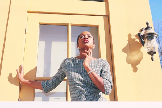 一位时尚女性身着连衣裙，在明媚的阳光下自信地摆着姿势