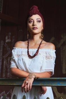 一位身穿白色连衣裙、佩戴珠宝的美丽女子在户外优雅地摆着姿势，自然光凸显了她的风采