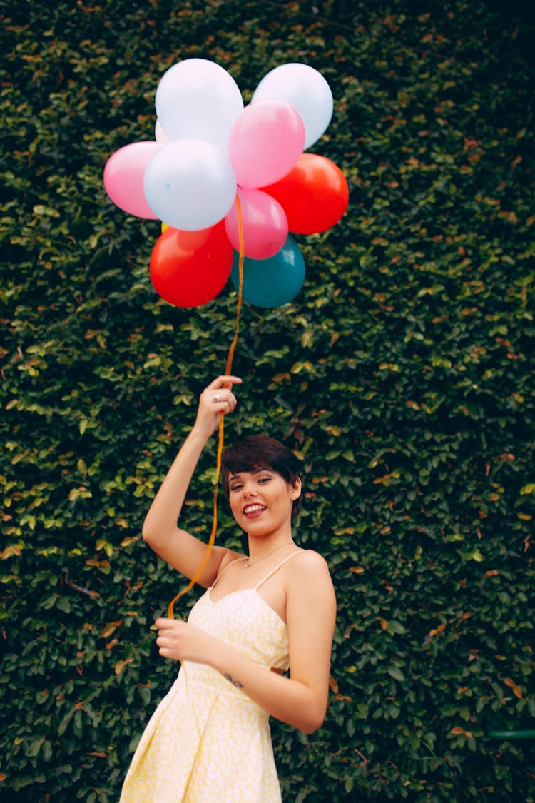 Photo Of Smiling Woman Holding Balloons