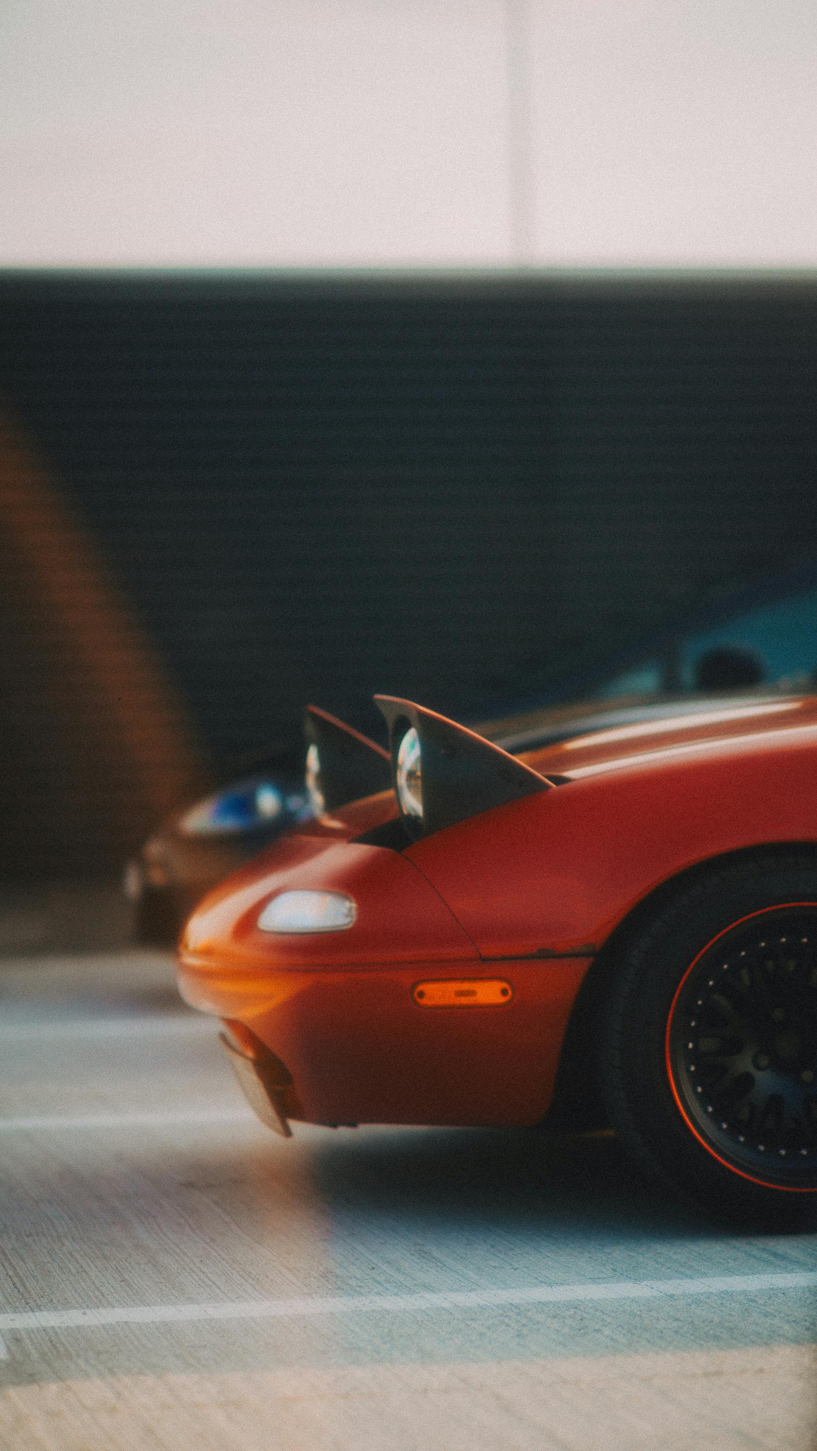 Free A red sports car with distinctive pop-up headlights parked in an urban environment. Stock Photo