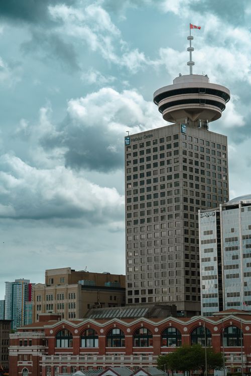 Free View of Vancouver's iconic Harbour Centre skyscraper under a cloudy sky. Stock Photo
