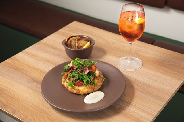 Delicious octopus dish served with Aperol spritz cocktail in a Puebla restaurant setting.