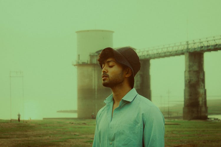 Film Photograph Of A Young Man In A Shirt And Bucket Hat Standing Outside 