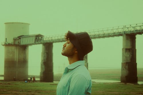 Film Photograph of a Young Man in a Shirt and Bucket Hat Standing Outside 