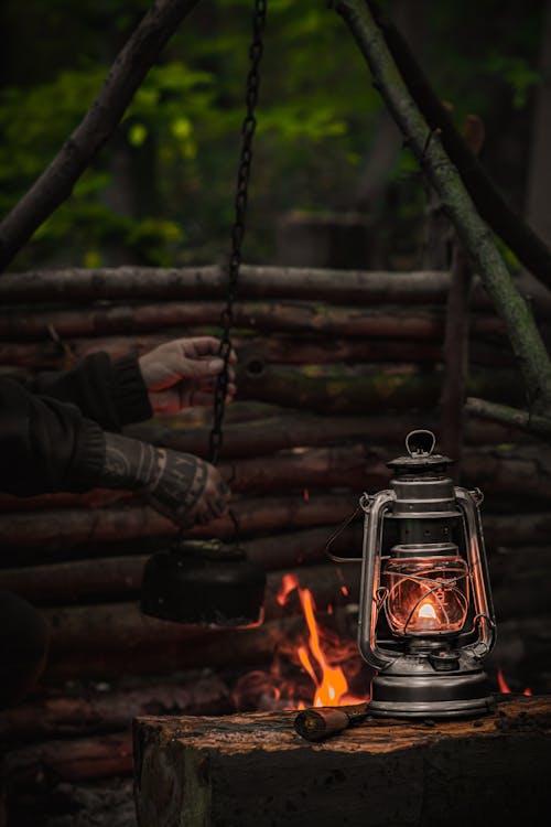 A Man Taking a Kettle off from a Chain Hanging over the Fire 