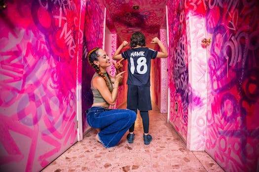 A joyful mother and son in a colorful, graffiti-filled corridor celebrating sportsmanship.