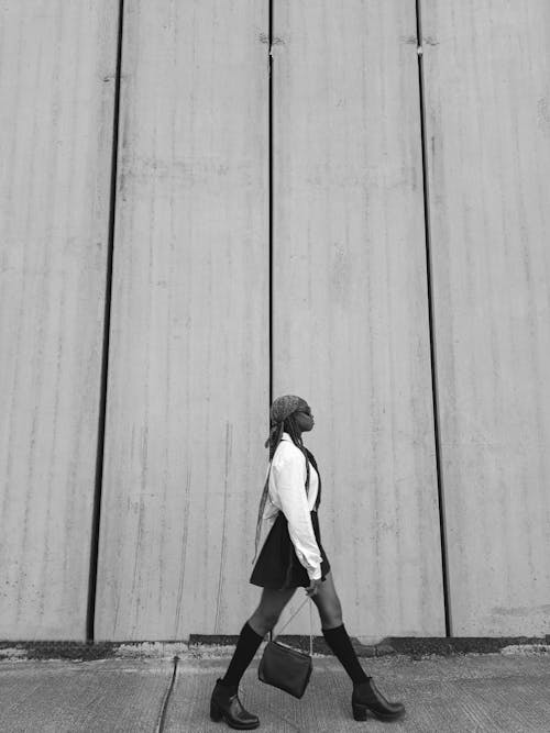 Woman with Bag Walking near Wall