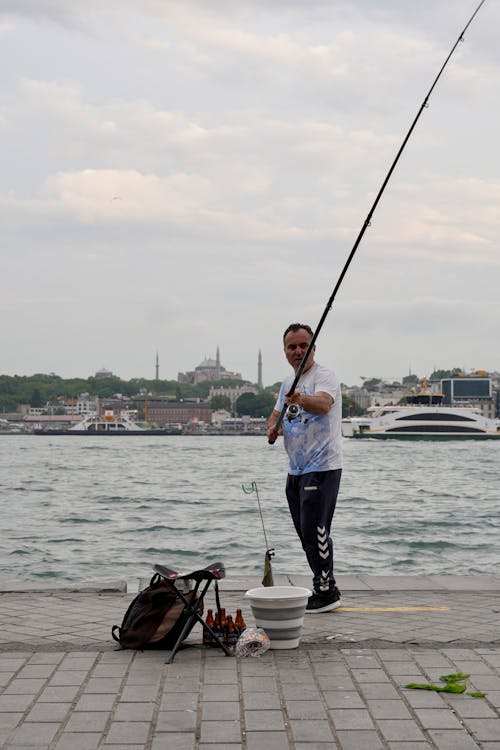 Fisherman Standing with Fishing Rod on Shore in Istanbul · Free