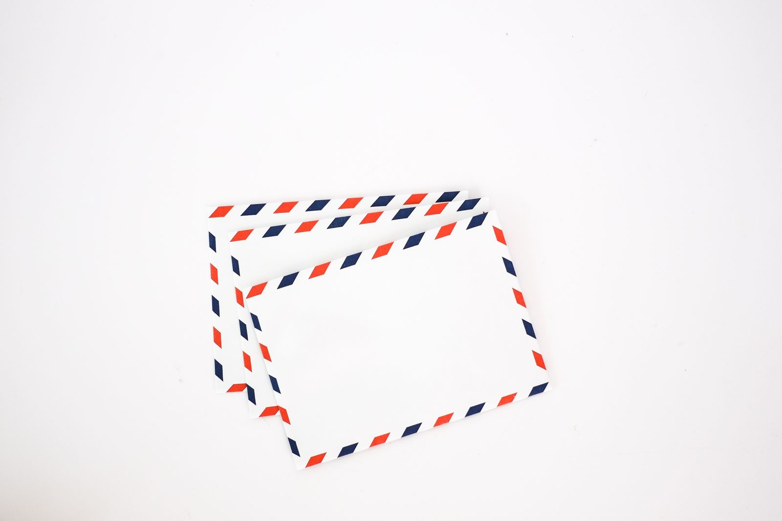 Two airmail envelopes with red and blue striped edges on a white background