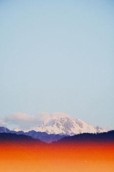 Scenic view of Talgar mountains with snowcaps and vivid sunset hues in Almaty Province, Kazakhstan.