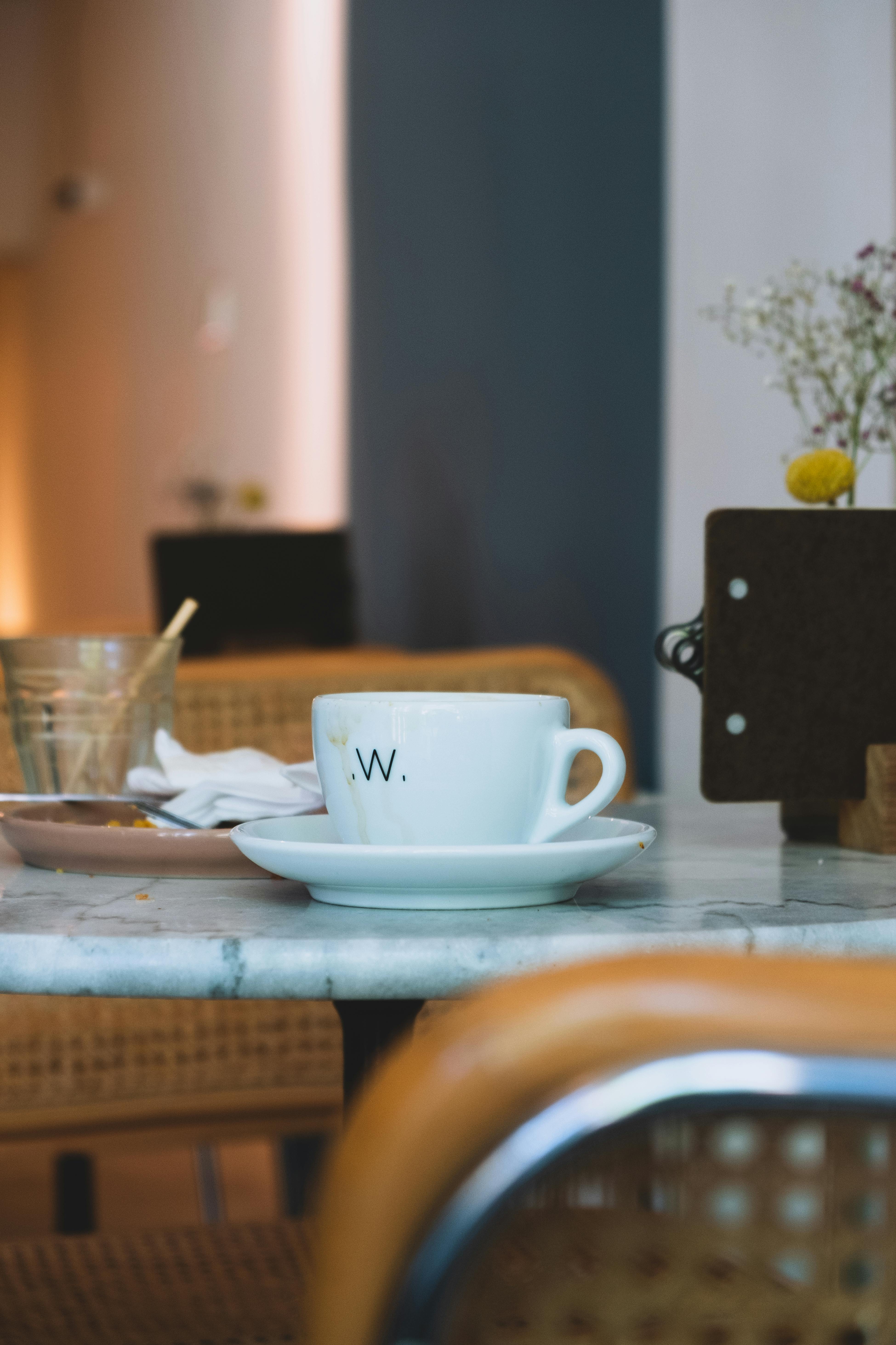 A Woman Sitting on a Bench Holding a Coffee Paper Cup · Free Stock Photo