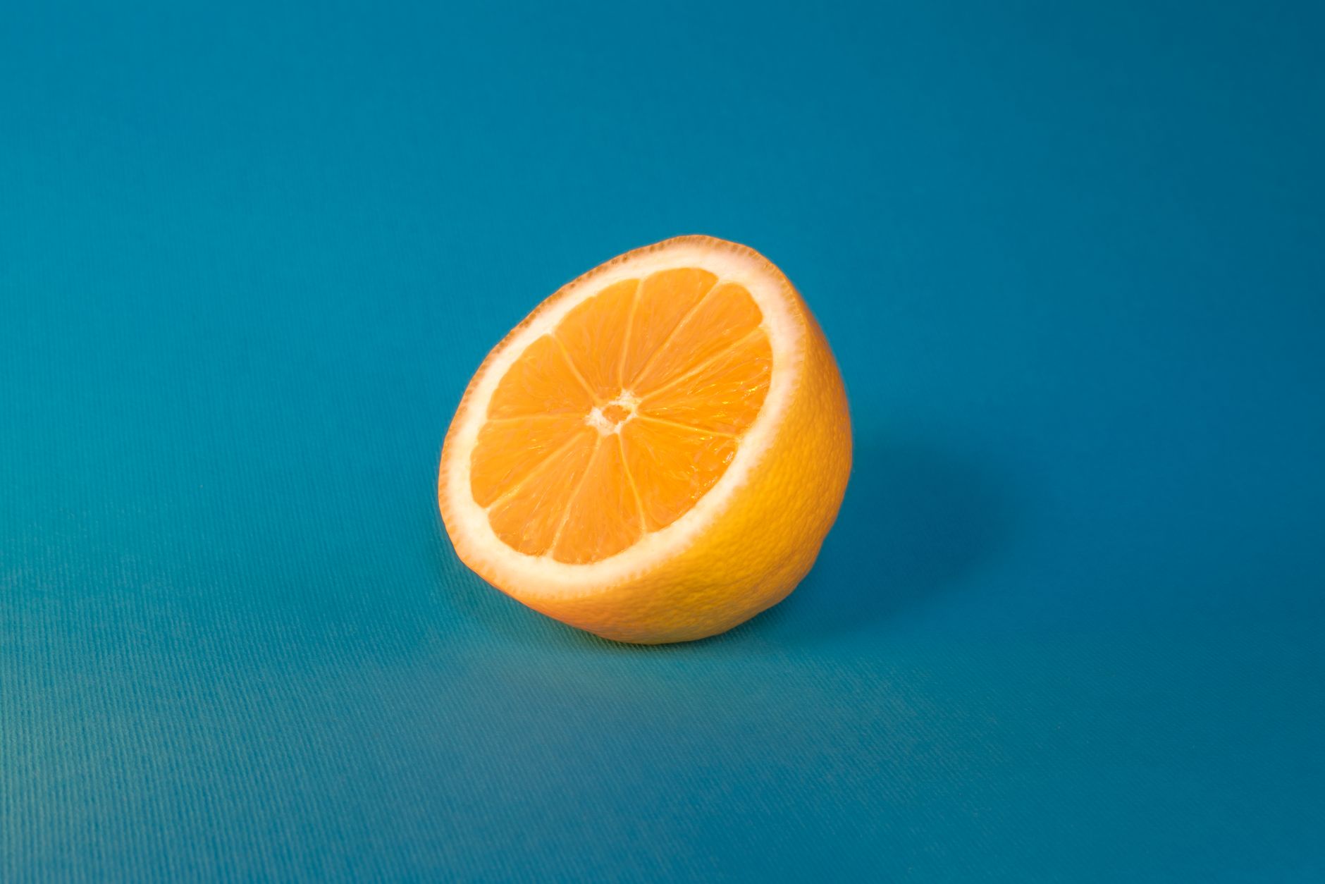 A fresh lemon slice set against a vibrant blue backdrop for a stunning contrast.