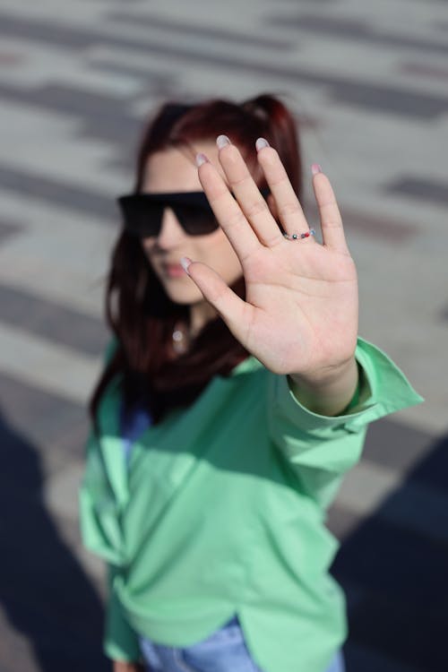 Raised Hand of Woman in Green Clothes