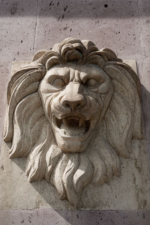 Free Close-up of a stone lion sculpture on a wall, showcasing intricate carvings and texture. Stock Photo
