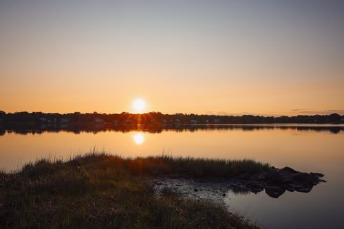 Free Capture the tranquil beauty of a lake at sunset with vibrant reflections in calm water. Stock Photo