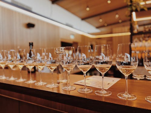 White Wine in Wineglasses Standing in a Row on a Bar Counter 