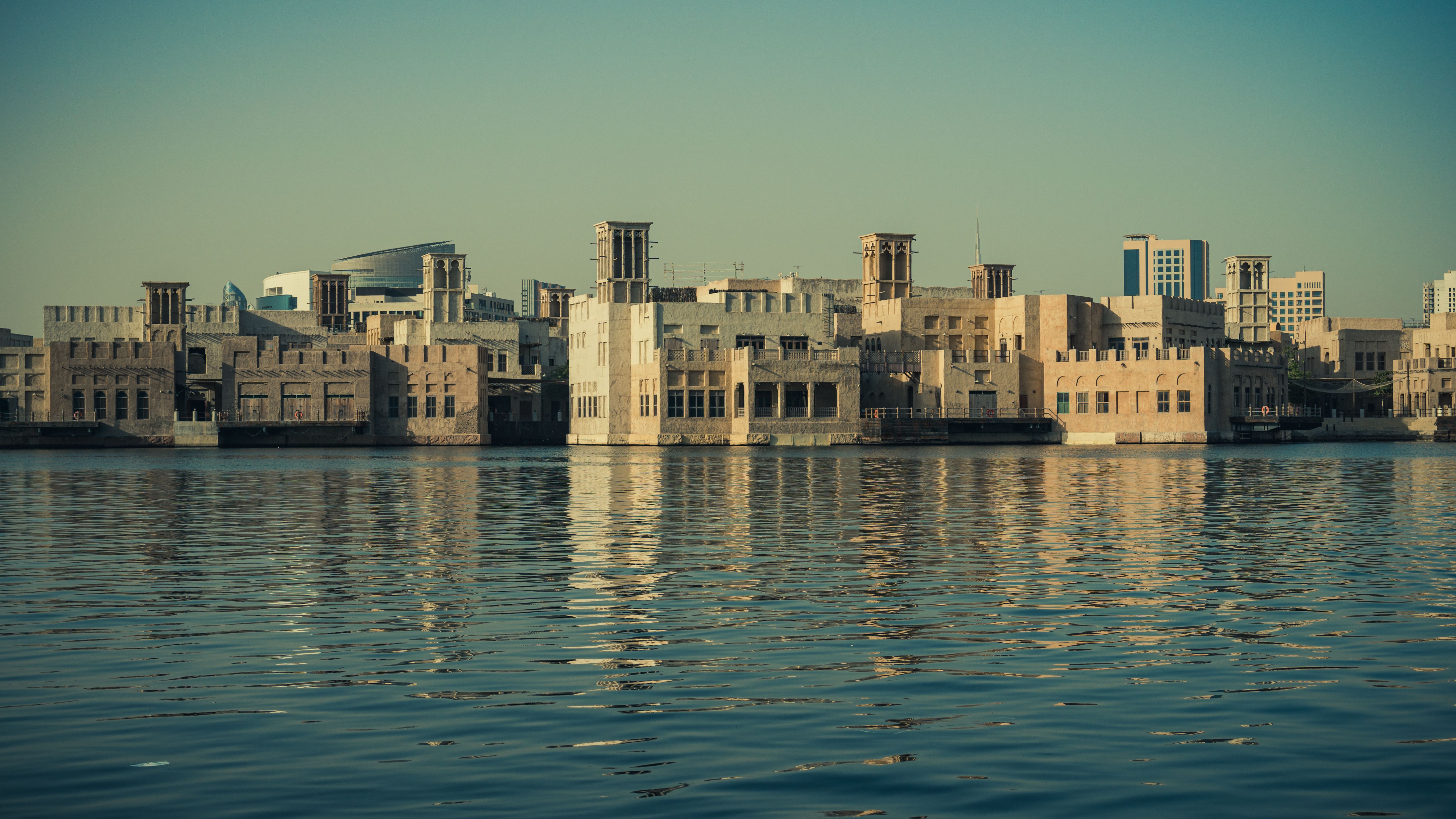 Scenic view of modern architecture reflecting on the Dubai Creek waters, showcasing Dubai's waterfront skyline.