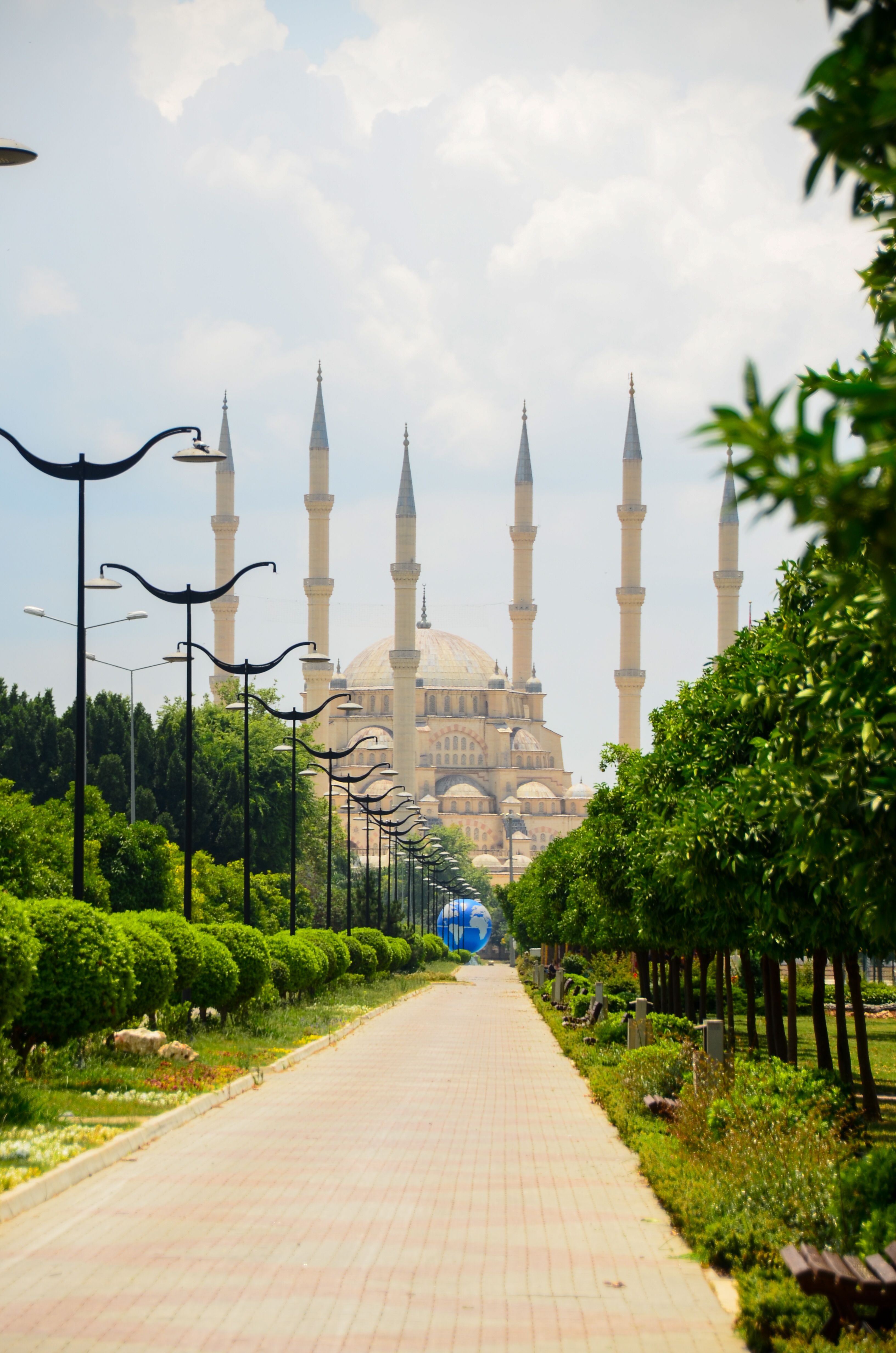 Scenic view of Sabanci Central Mosque with lush green park pathway in Adana, Turkey.