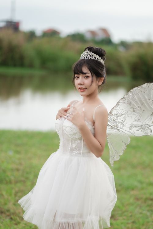 Free Magical portrait of a woman dressed as a fairy bride with wings, set in a serene outdoor environment. Stock Photo