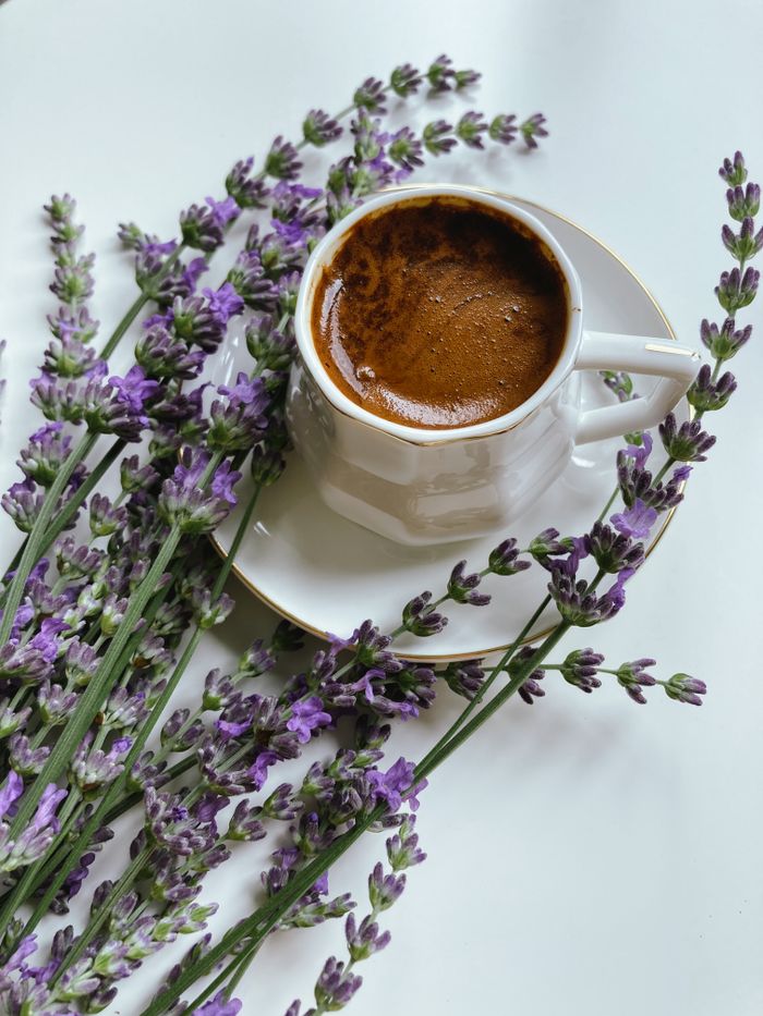 A coffee cup surrounded by delicate lavender sprigs