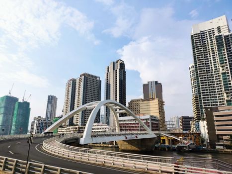 A contemporary bridge amid skyscrapers in Manila, showcasing urban development.
