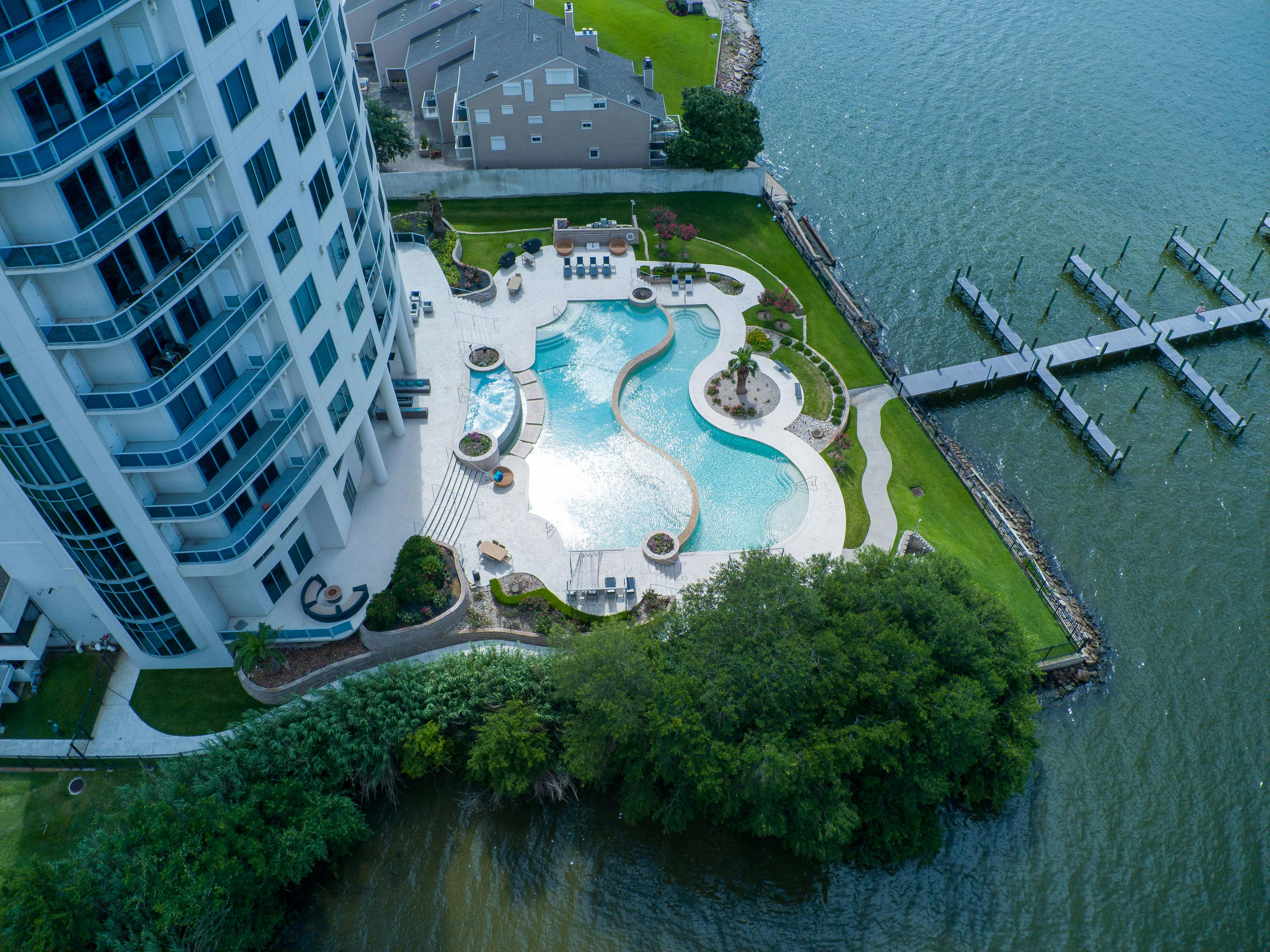 an aerial view of a pool and dock at a waterfront home