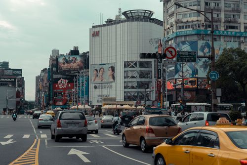 Free Traffic and vibrant billboards on a busy Taipei street capture urban life. Stock Photo