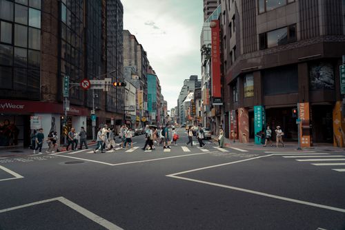 Free A busy urban intersection with people crossing surrounded by modern buildings, showcasing city life. Stock Photo