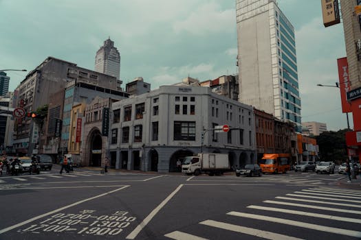 Busy street intersection in Taipei with modern architecture and urban traffic.