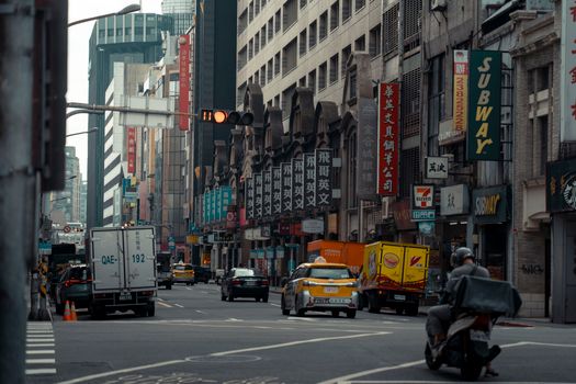 Urban street in a vibrant city with traffic and modern architecture.