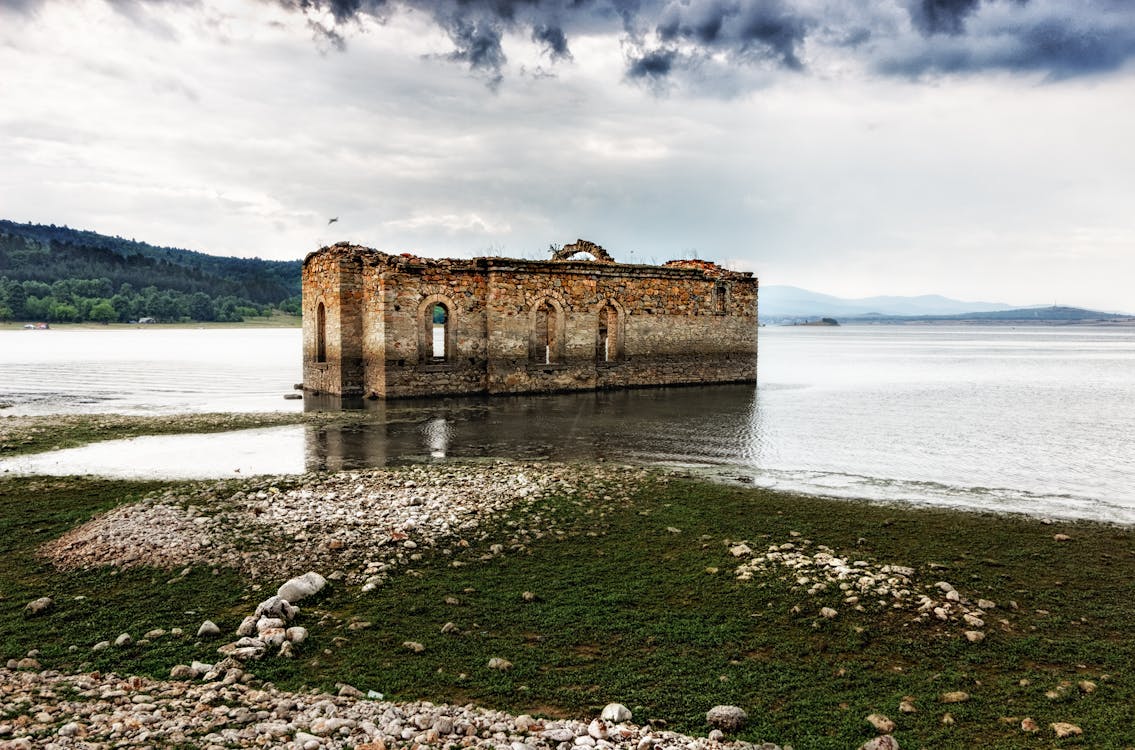 Free Gray and Brown Building on Body of Water Under Cloudy Sky during Daytime Stock Photo