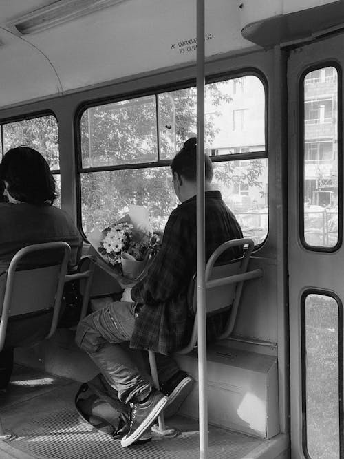Person Sitting with Flowers Bouquet on Bus