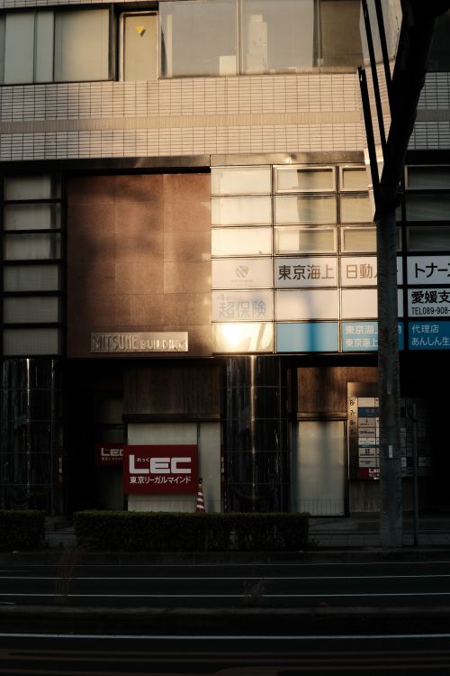 Free A serene cityscape featuring an urban building facade illuminated by warm sunset light. Stock Photo