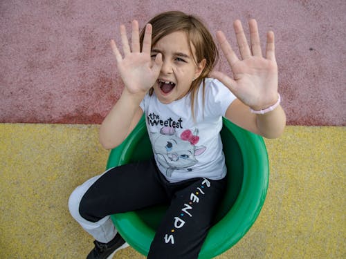 Girl Sitting and Shouting with Hands Raised Up