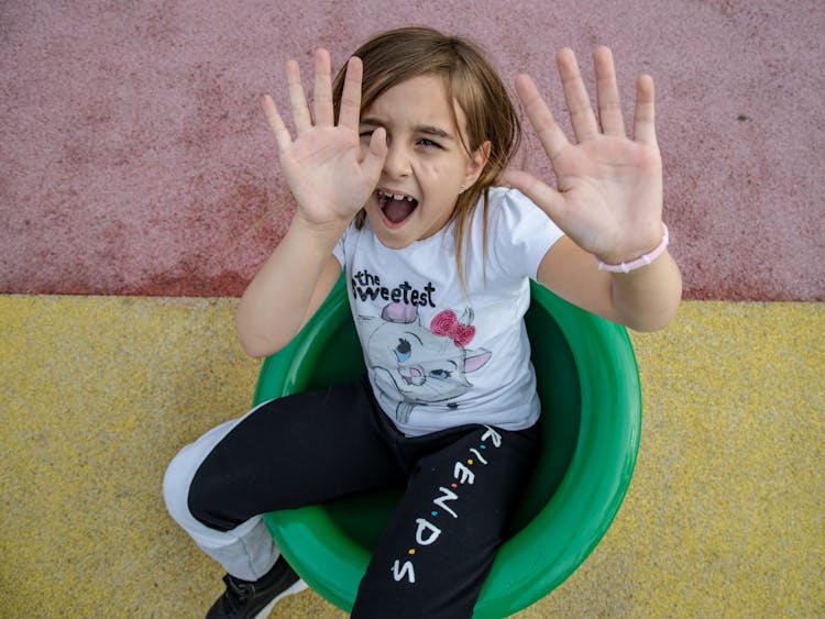 Girl Sitting And Shouting With Hands Raised Up