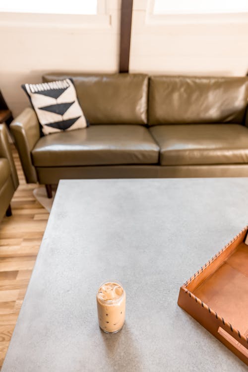 A coffee cup sits on a table next to a couch