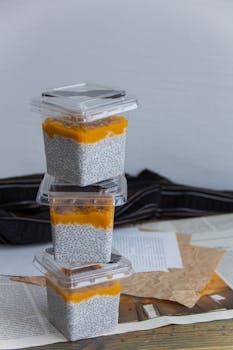 Stacked chia pudding containers with mango topping, perfect for healthy snacking.