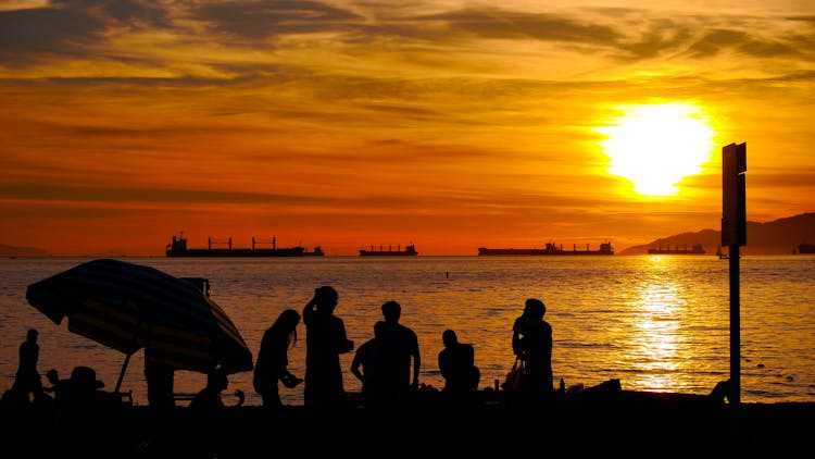 Silhouettes Of A Family On A Beach At Sunset