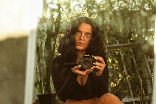 Woman Sitting with Camera by Mirror