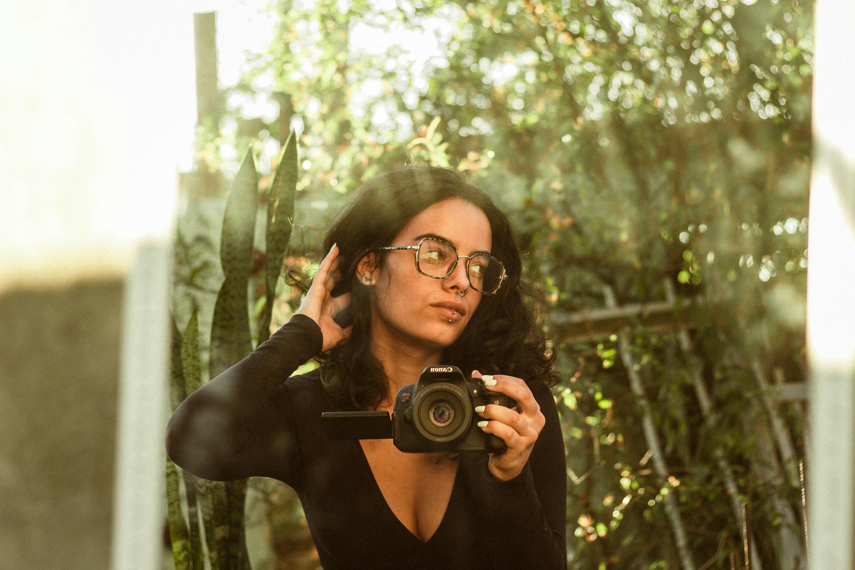 A woman captures a mirrored self-portrait outdoors, creating an artistic reflection.