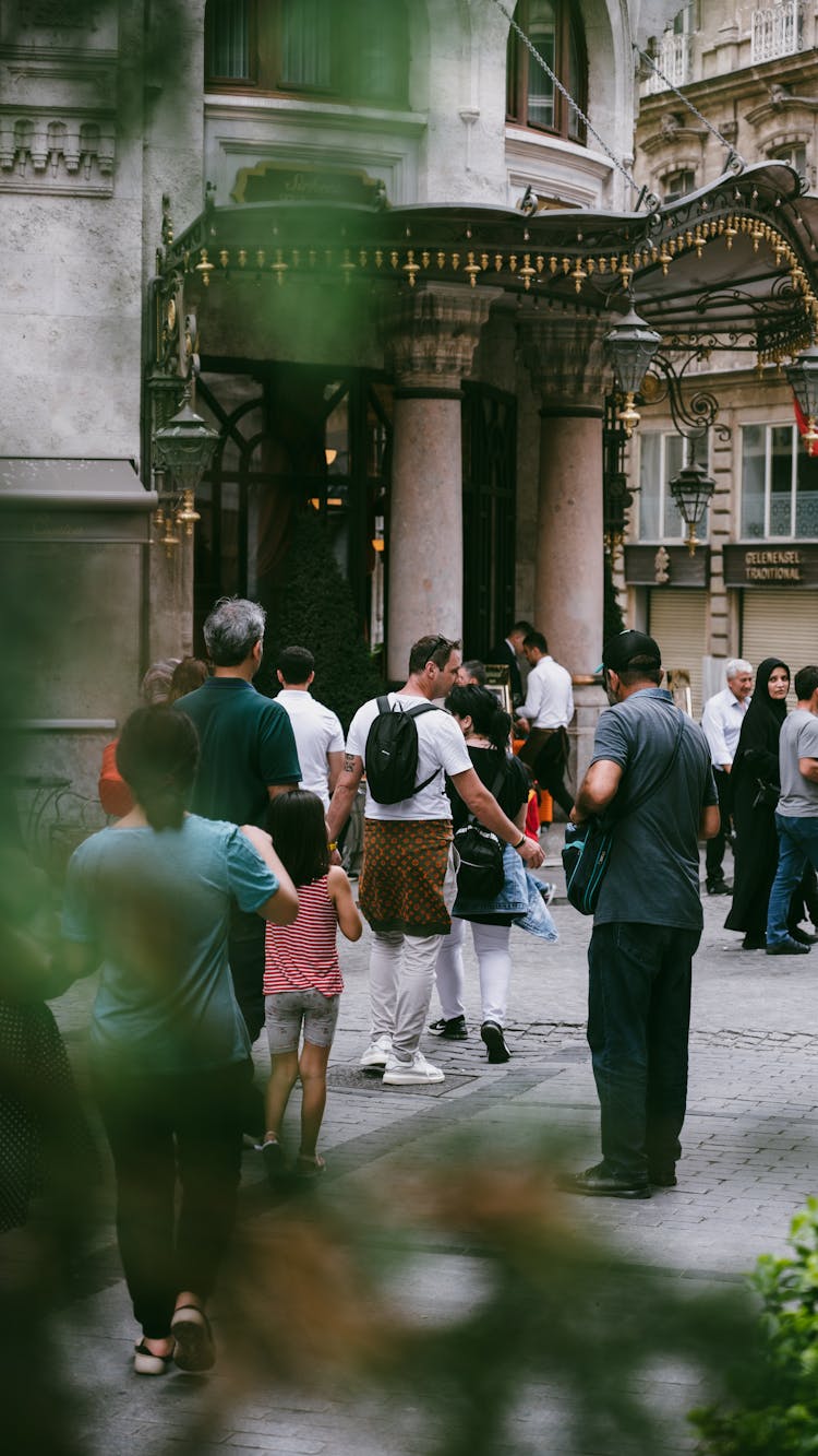 People On Pavement Near Building With Columns